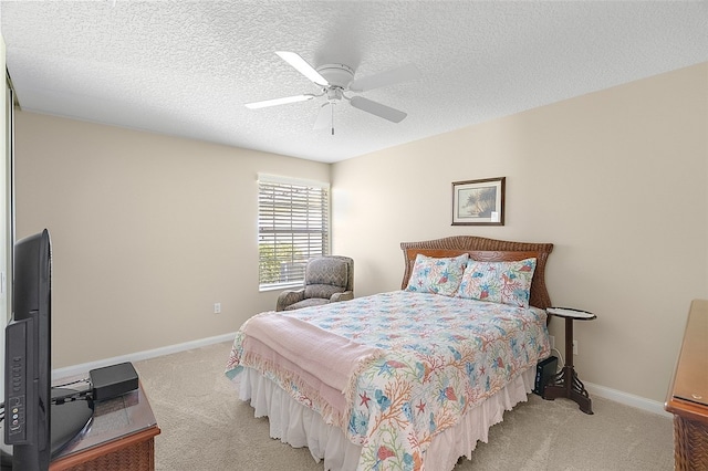 carpeted bedroom featuring ceiling fan and a textured ceiling