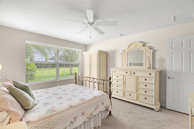 bedroom with light carpet, a textured ceiling, and ceiling fan