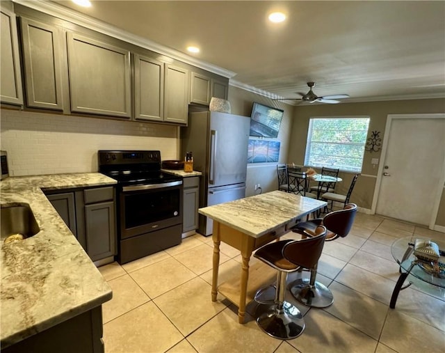 kitchen featuring light stone counters, electric range, stainless steel fridge, and light tile patterned flooring