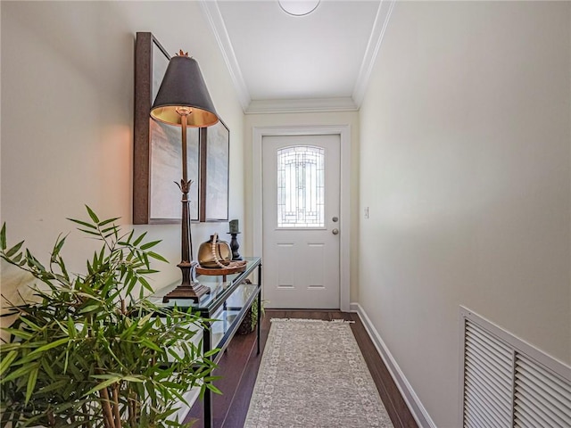 doorway with crown molding, wood finished floors, baseboards, and visible vents