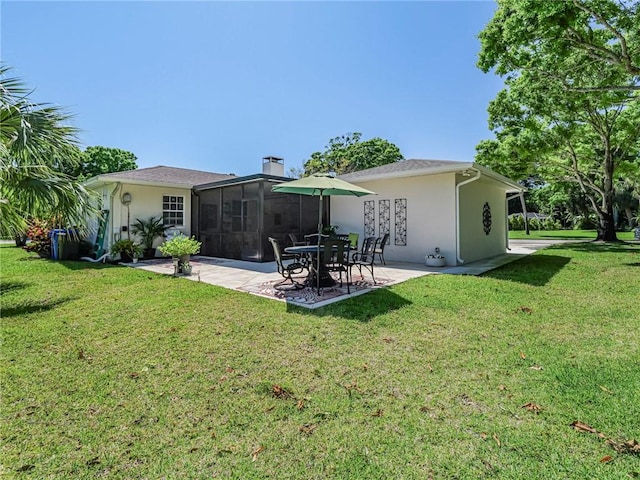 back of house featuring stucco siding, a sunroom, a lawn, and a patio area