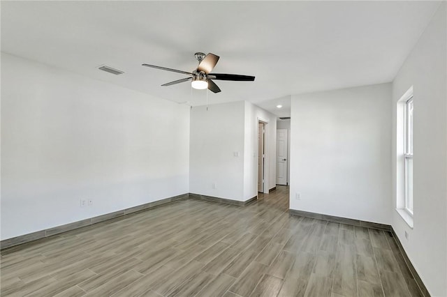 empty room with ceiling fan and light wood-type flooring