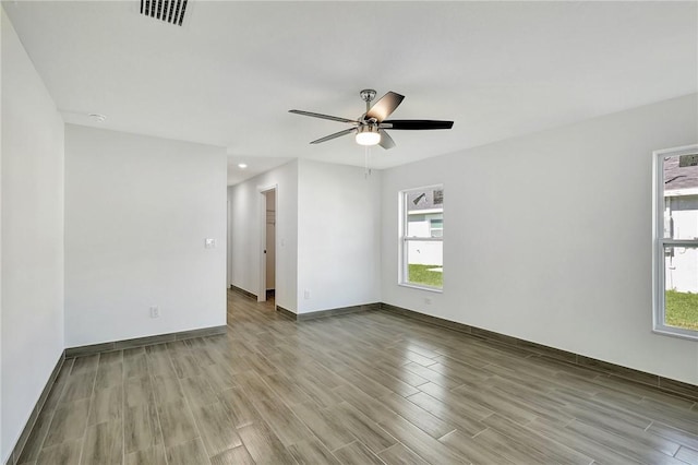 empty room with ceiling fan and light hardwood / wood-style flooring