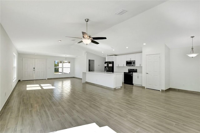 unfurnished living room with ceiling fan, vaulted ceiling, and light hardwood / wood-style flooring