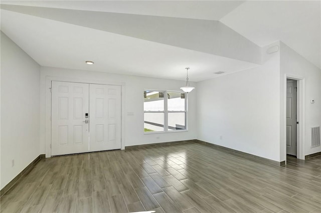 entrance foyer with vaulted ceiling and hardwood / wood-style floors