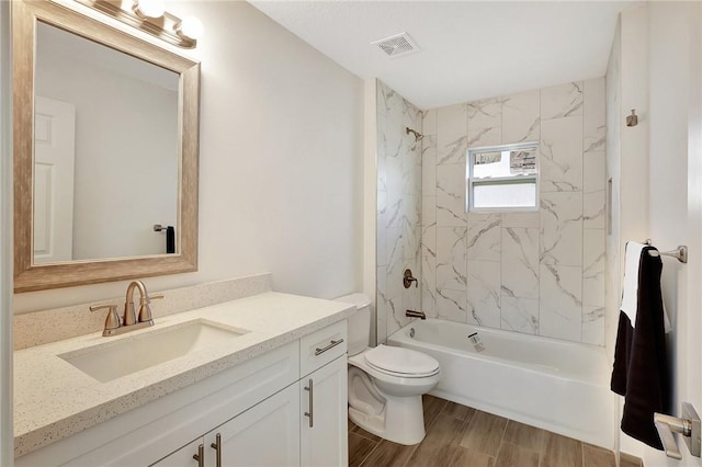 full bathroom with vanity, tiled shower / bath combo, and toilet