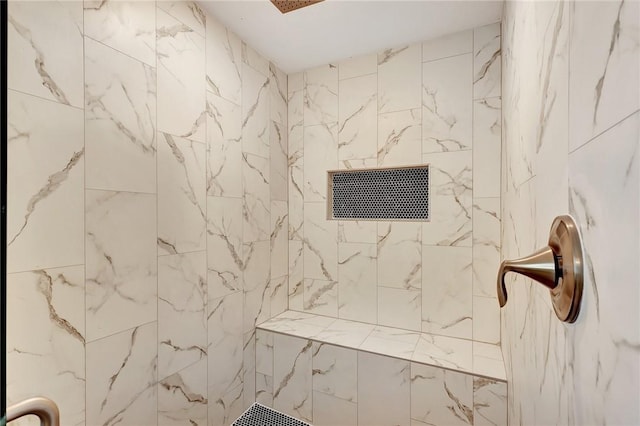 interior details featuring a tile shower