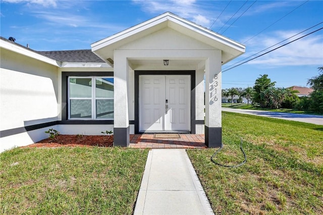 view of exterior entry featuring a yard