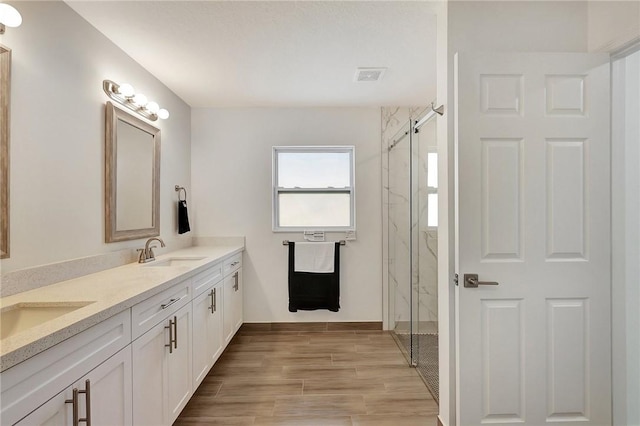 bathroom featuring vanity and an enclosed shower