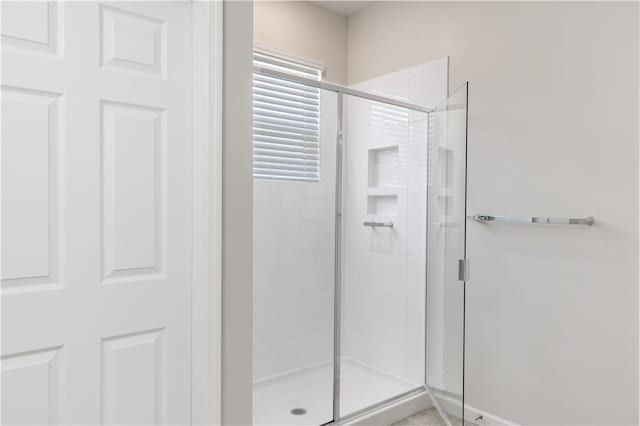 bathroom featuring a shower with door