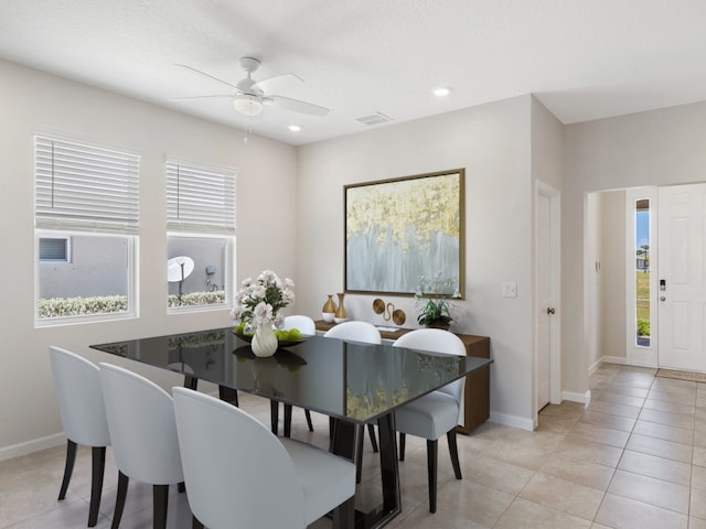 tiled dining area featuring ceiling fan, a textured ceiling, and a healthy amount of sunlight