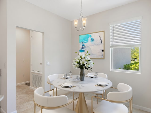 tiled dining area featuring a chandelier