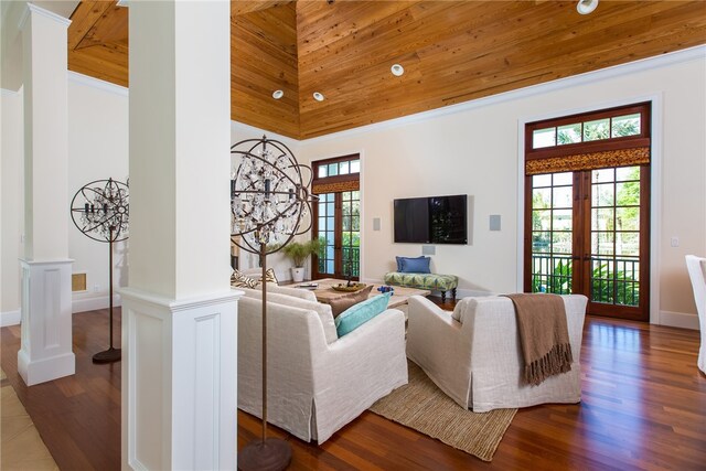 living room featuring a high ceiling, wood-type flooring, ornate columns, and french doors