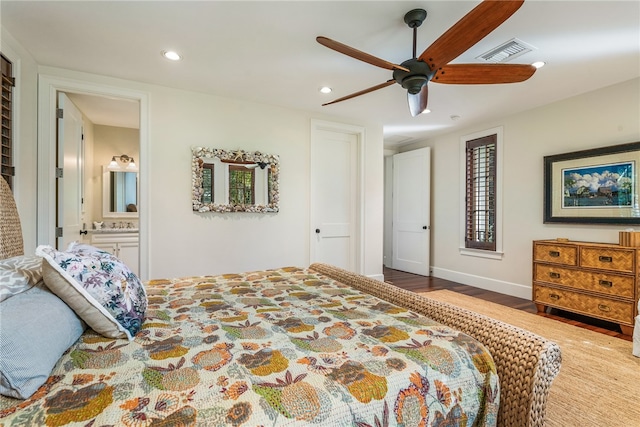 bedroom featuring connected bathroom, wood-type flooring, and ceiling fan