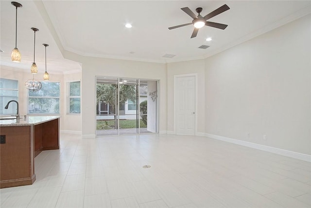 unfurnished living room featuring ceiling fan with notable chandelier, ornamental molding, sink, and light tile patterned floors