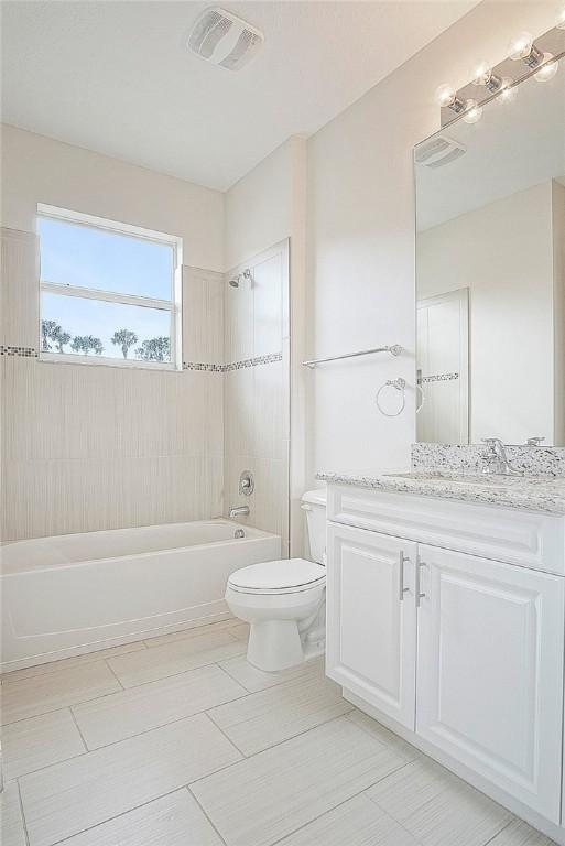 full bathroom featuring vanity, toilet, and tiled shower / bath