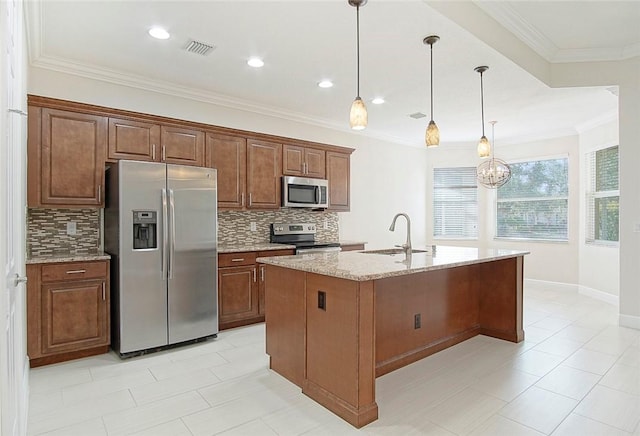 kitchen with pendant lighting, sink, an island with sink, tasteful backsplash, and stainless steel appliances