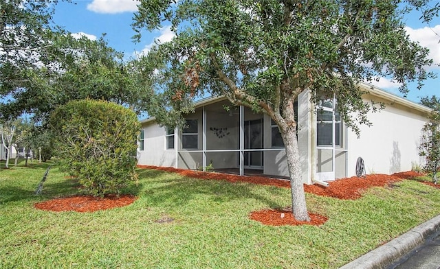 view of front of home with a sunroom and a front yard