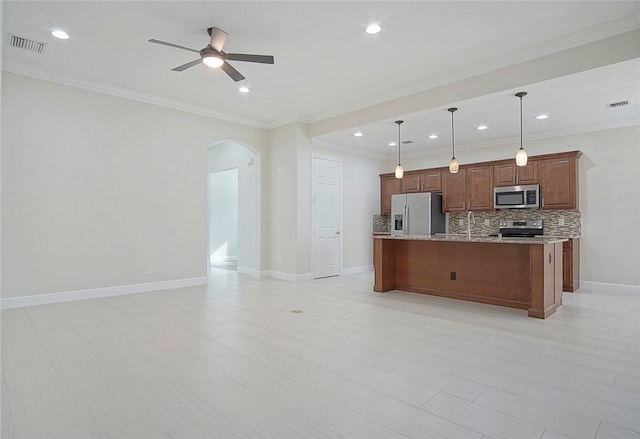 kitchen with pendant lighting, a center island with sink, ceiling fan, decorative backsplash, and stainless steel appliances