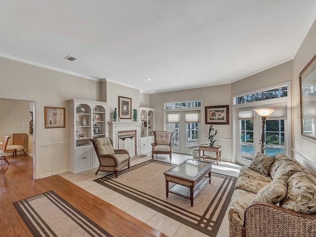 living room featuring crown molding, light wood-type flooring, and french doors