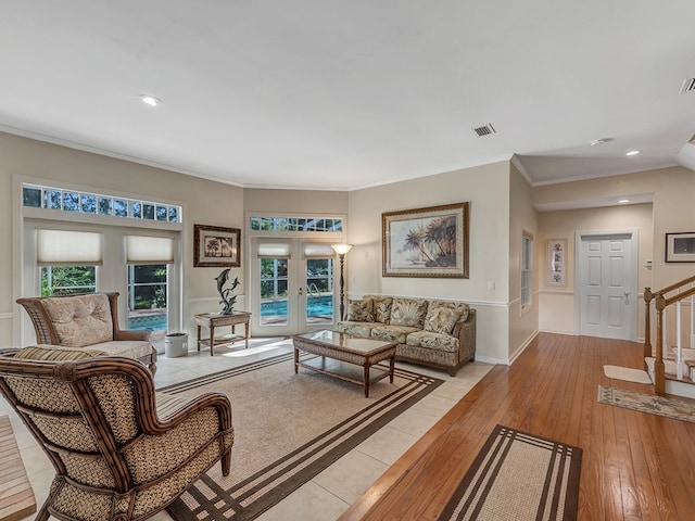 living room with french doors, light wood-type flooring, and crown molding