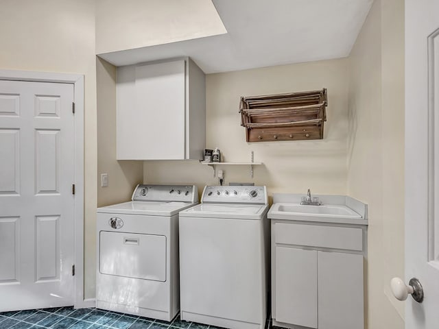 laundry area featuring washing machine and clothes dryer, cabinets, and sink