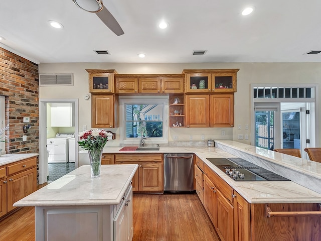 kitchen with black electric cooktop, washer and dryer, plenty of natural light, and dishwasher