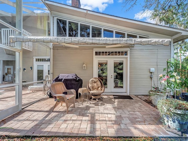 1516 50th Ct, Vero Beach, FL 32966 - rear view of house with french doors, a patio area, a chimney, and glass enclosure