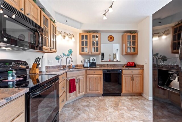 kitchen featuring stone countertops, sink, and black appliances