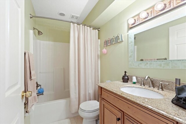 full bathroom featuring tile patterned flooring, vanity, toilet, and shower / bath combination with curtain