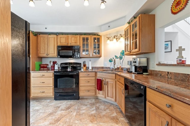 kitchen featuring stone countertops, sink, and black appliances