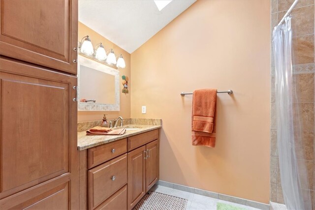 bathroom featuring vanity, a shower with shower curtain, tile patterned flooring, and vaulted ceiling