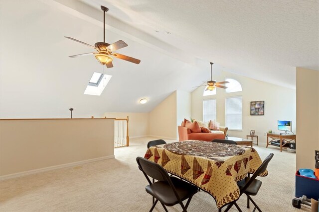 interior space with light colored carpet, ceiling fan, and lofted ceiling with skylight