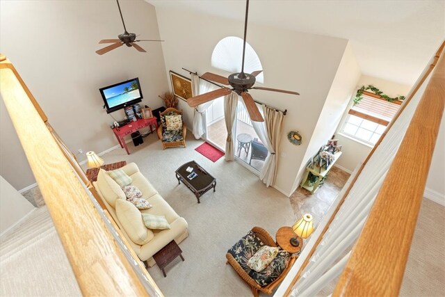 carpeted living room with high vaulted ceiling and ceiling fan