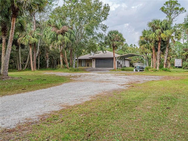 view of front facade featuring a front lawn, a garage, and a carport