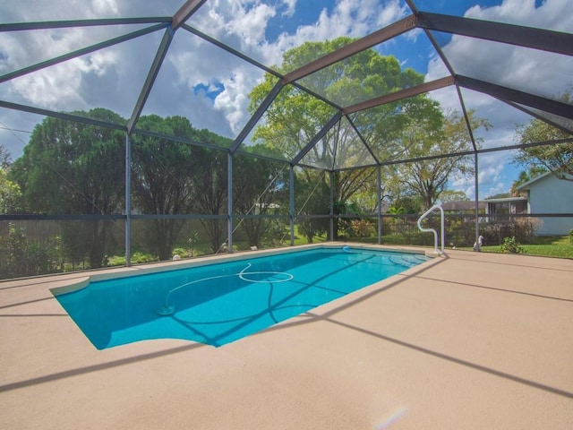 pool with glass enclosure and a patio