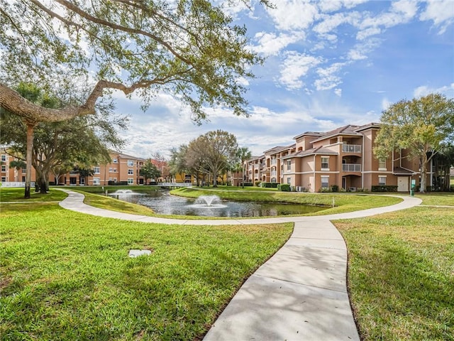 view of community with a yard and a water view