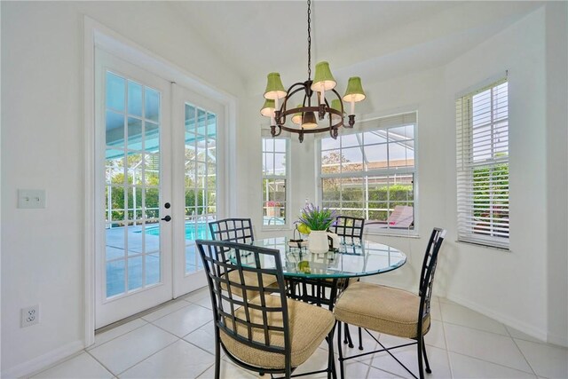 dining room with light tile patterned floors, french doors, baseboards, and a chandelier