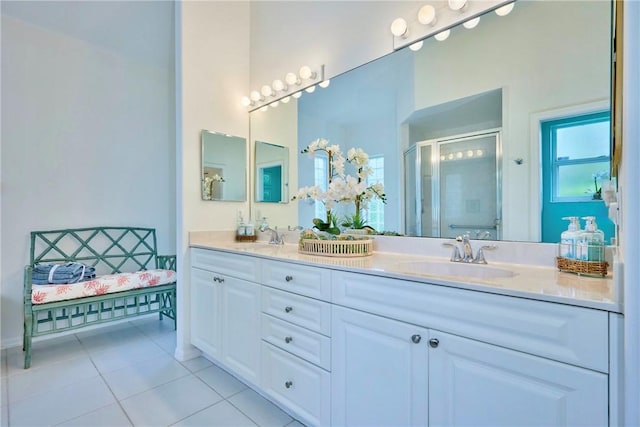 full bathroom featuring tile patterned flooring, a shower stall, double vanity, and a sink