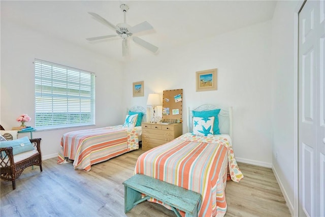 bedroom with a closet, baseboards, wood finished floors, and a ceiling fan