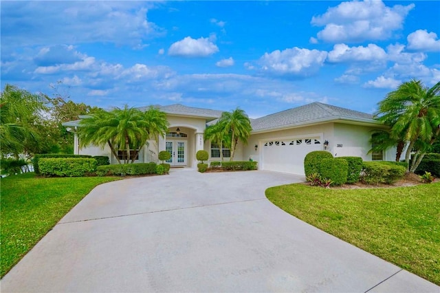 view of front facade featuring a front yard, an attached garage, stucco siding, concrete driveway, and french doors