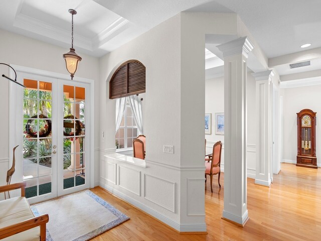 interior space featuring french doors, light wood-type flooring, and a tray ceiling