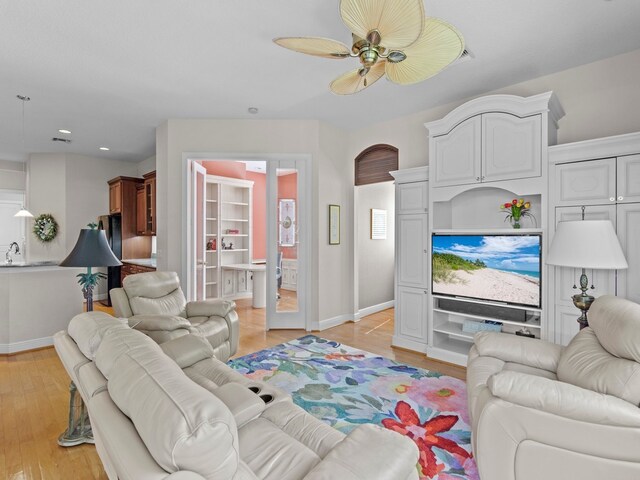 living room featuring ceiling fan and light hardwood / wood-style floors