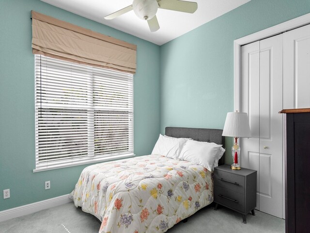 carpeted bedroom with ceiling fan and a closet