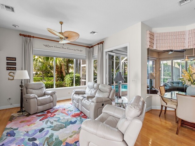 living room featuring light wood-type flooring and ceiling fan