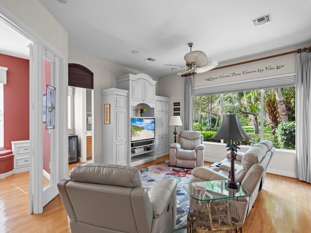 living room featuring light wood-type flooring and ceiling fan