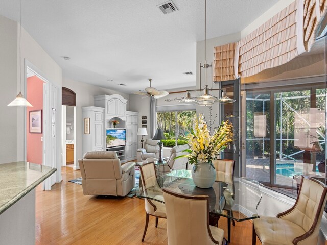 dining room with ceiling fan, a wealth of natural light, and light hardwood / wood-style floors