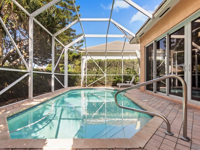 view of swimming pool featuring a patio area and a lanai