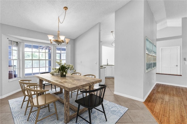 115 Larchmont Ter, Sebastian, FL 32958 - dining space featuring a chandelier, light tile patterned floors, a textured ceiling, and high vaulted ceiling