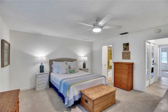 living room with ceiling fan, light tile patterned floors, and a textured ceiling